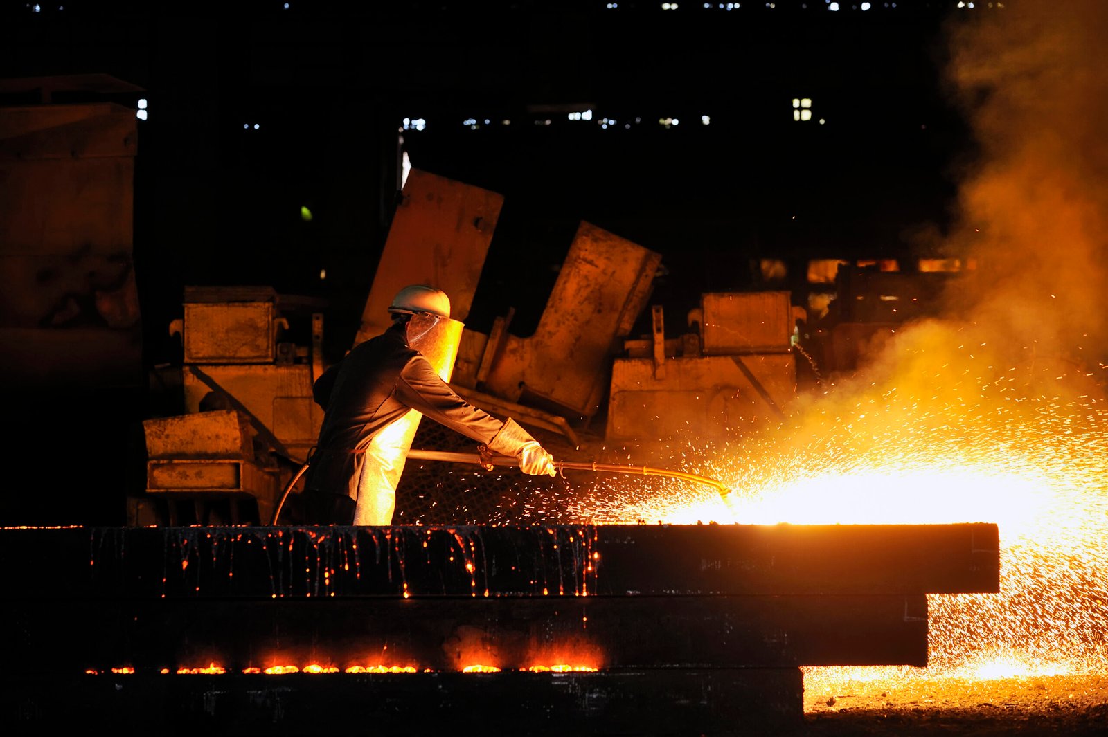worker using torch cutter to cut through metal
